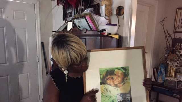 Minister Brenda Ward, founder of Cash for Crooks, holds a picture of her son.