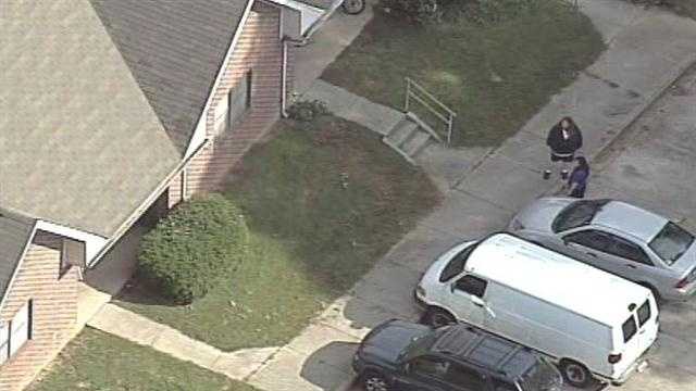 Coroner: Man found shot to death between 2 vehicles in parking lot