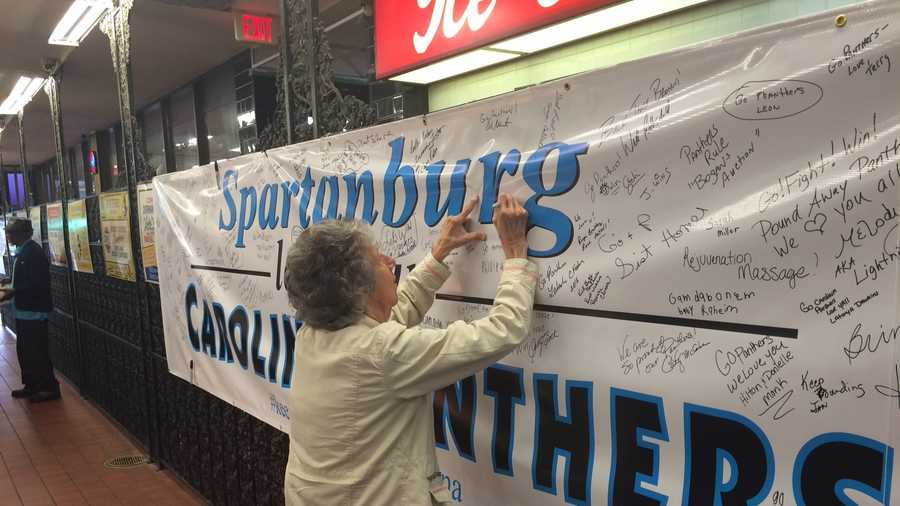 JoAnn Adams signs a banner for the Panthers at The Beacon in Spartanburg.