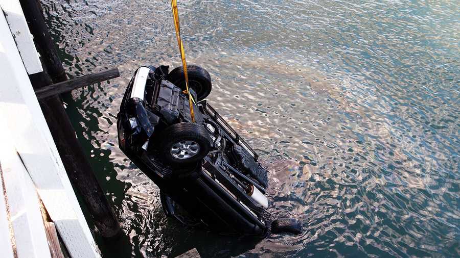 An SUV is lifted out of the ocean after a 16-year-old boy drove off the Santa Cruz Wharf. (Jan. 28, 2013 / Photo by Tim Cattera)