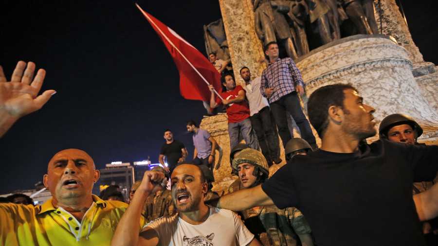 Supporters of Turkey's President Recep Tayyip Erdogan, protest in front of soldiers in Istanbul's Taksim square, early Saturday. Turkey's prime minister says a group within Turkey's military has engaged in what appeared to be an attempted coup. 