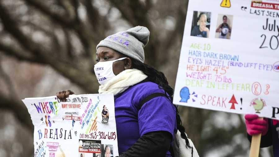 Keondra Robinson, of Davenport, holds a sign in honor of missing Breasia Terrell, 10, of Davenport, along 53rd Street Saturday, Nov. 14, 2020, in Davenport, Iowa. Breasia went missing sometime late July 9 or early July 10, and was last seen in the 2700 block of East 53rd Street. (Meg McLaughlin/Quad City Times via AP)