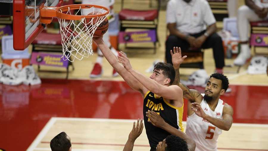 Iowa center Luka Garza, top left, goes to the basket between Maryland forward Donta Scott (24) and guard Eric Ayala (5) during the first half of an NCAA college basketball game, Thursday, Jan. 7, 2021, in College Park, Md. (AP Photo/Nick Wass)