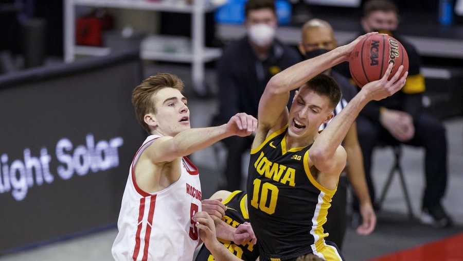 Iowa's Joe Wieskamp (10) pulls down a defensive rebound against Wisconsin's Tyler Wahl (5) during the first half of an NCAA college basketball game Thursday, Feb. 18, 2021, in Madison, Wis. (AP Photo/Andy Manis)