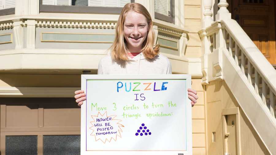 ella klein holds one of her puzzles
