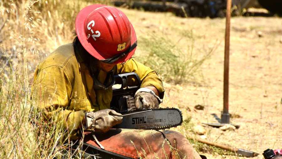 firefighter performs maintenance on chainsaw.