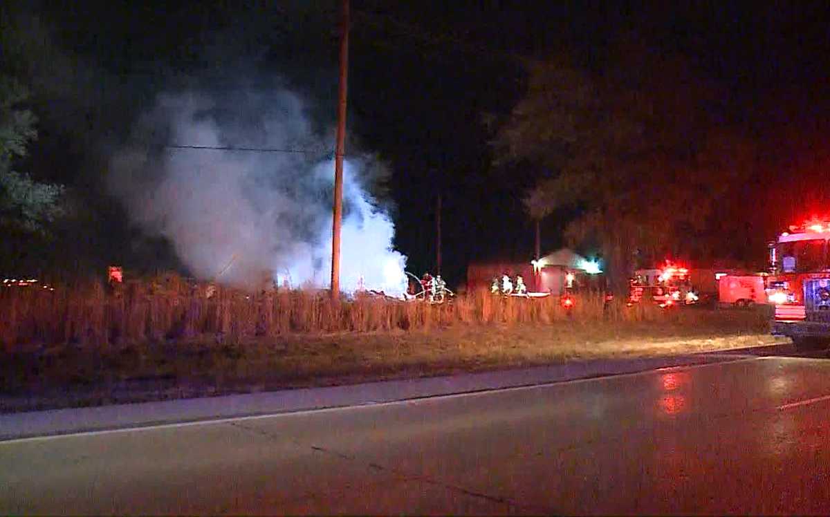Fire crews shuttle in water to battle flames at home set to be demolished