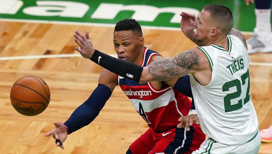 Washington Wizards guard Russell Westbrook (4) passes the ball under pressure from Boston Celtics center Daniel Theis (27) during the first quarter of an NBA basketball game Friday, Jan. 8, 2021, in Boston. (AP Photo/Elise Amendola)