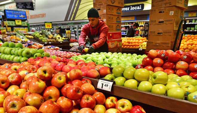 Apples&#x20;are&#x20;stacked&#x20;for&#x20;display&#x20;and&#x20;sale&#x20;as&#x20;people&#x20;shop&#x20;at&#x20;a&#x20;grocery&#x20;store