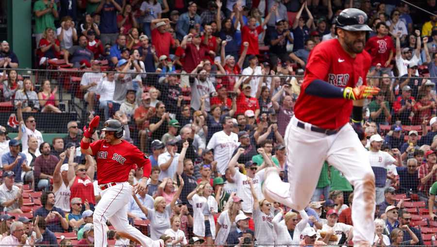 Boston Red Sox&apos;s Christian Vazquez, left, scores on a single by J.D. Martinez, right, during the eighth inning of a baseball game against the Oakland Athletics at Fenway Park, Thursday, June 16, 2022, in Boston. (AP Photo/Mary Schwalm)