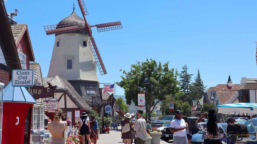tourists take photos of a windmill in solvang, ca on june 26, 2021