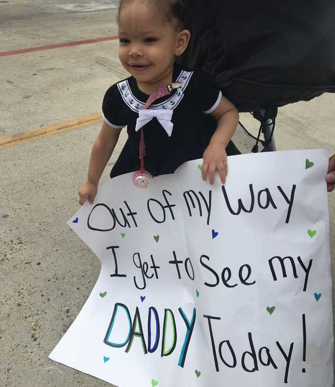 Young daughters face lights up when Navy dad is reunited