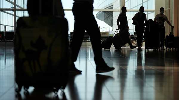 Passenger walk through the arrival lobby of Haneda Airport in Tokyo on October 11.