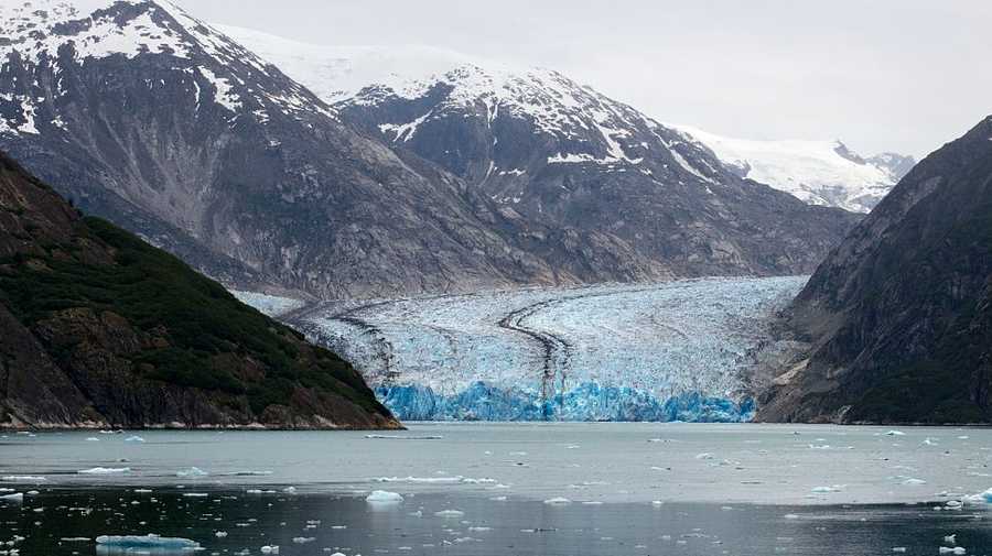 Safari Endeavour cruise passengers in an inflatable boat in front of South Sawyer Glacier calves into the Endicott Arm fjord of Tracy Arm in Fords Terror Wilderness, Southeast, Alaska.