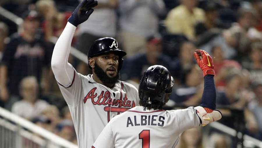 Atlanta Braves' Marcell Ozuna, left, celebrates with teammate Ozzie Albies (1) after hitting a two-run home run during the third inning of a baseball game against the Washington Nationals, Monday, June 13, 2022, in Washington. (AP Photo/Luis M. Alvarez)