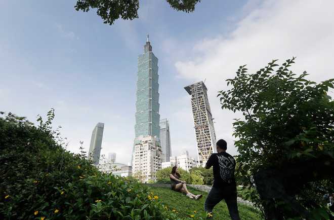 FILE - People take photos with the iconic Taipei 101 skyscraper in the background in Taipei, Taiwan, April 27, 2025.