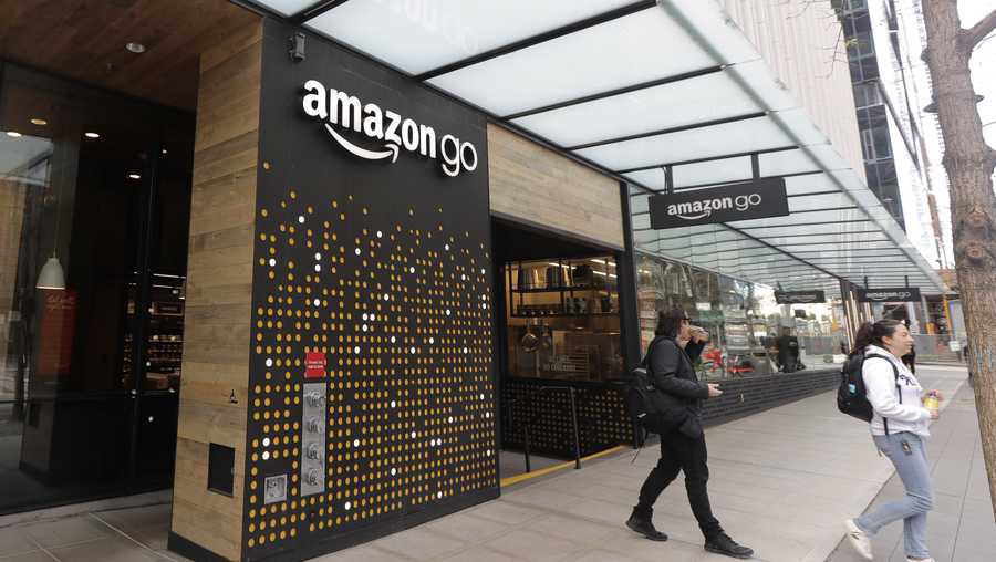 In this March 4, 2020 file photo, people walk out of an Amazon Go store, in Seattle.  Amazon said Wednesday, April 21, 2021 that it is rolling out its pay-by-palm technology to some of its Whole Foods supermarkets.