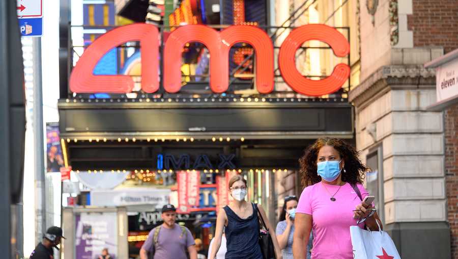 People wear protective face masks outside the AMC Empire 25 movie theater in Times Square as the city continues Phase 4 of re-opening following restrictions imposed to slow the spread of coronavirus on August 5, 2020 in New York City.