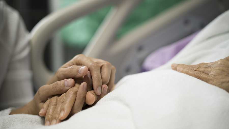 Close up  of daughter or caregiver holding hand of her mother on bed to give encouragement  in the hospital.
