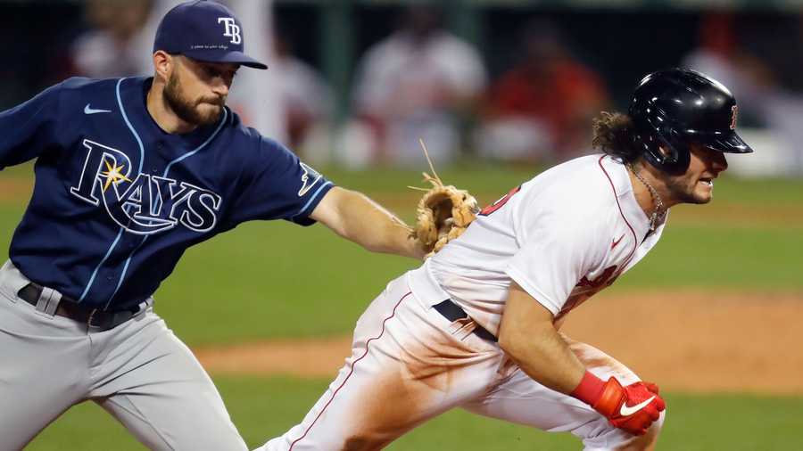 Tampa Bay Rays' Brandon Lowe tags Boston Red Sox's Andrew Benintendi on a run down at third base during the eighth inning of a baseball game, Tuesday, Aug. 11, 2020, in Boston. (AP Photo/Michael Dwyer)