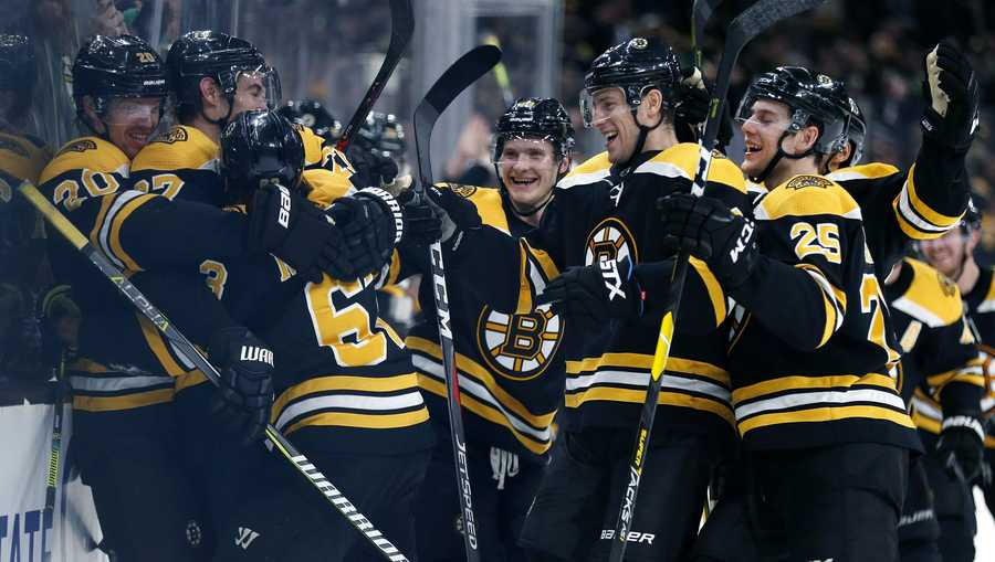 Boston Bruins celebrate after a goal by Brad Marchand (63) during overtime in an NHL hockey game against the Columbus Blue Jackets in Boston, Saturday, March 16, 2019. (AP Photo/Michael Dwyer)