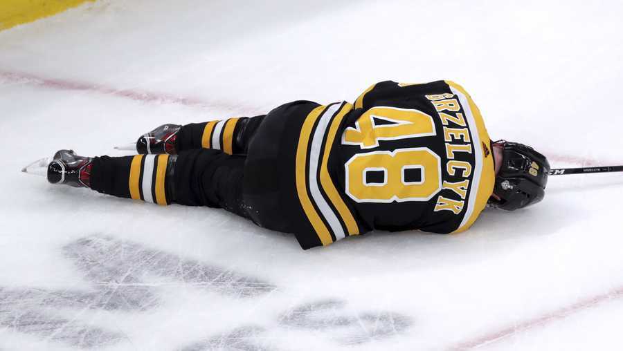 Boston Bruins' Matt Grzelcyk lies injured on the ice during the first period in Game 2 of the NHL hockey Stanley Cup Final against the St. Louis Blues, Wednesday, May 29, 2019, in Boston.