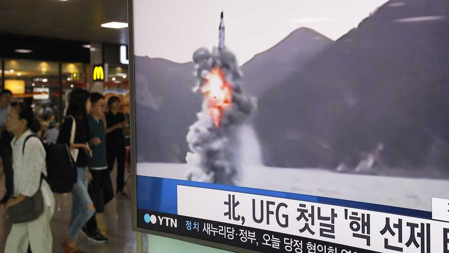 People pass by a TV news program showing a file footage of North Korea's ballistic missile that the North claimed to have launched from underwater, at Seoul Railway station in Seoul, South Korea, Wednesday, Aug. 24, 2016. North Korea on Wednesday fired a ballistic missile from a submarine into the sea in an apparent protest against the start of annual South Korea-U.S. military drills, Seoul's military said. The letters read "North Korea fired a missile during UFG, Ulchi Freedom Guardian." 