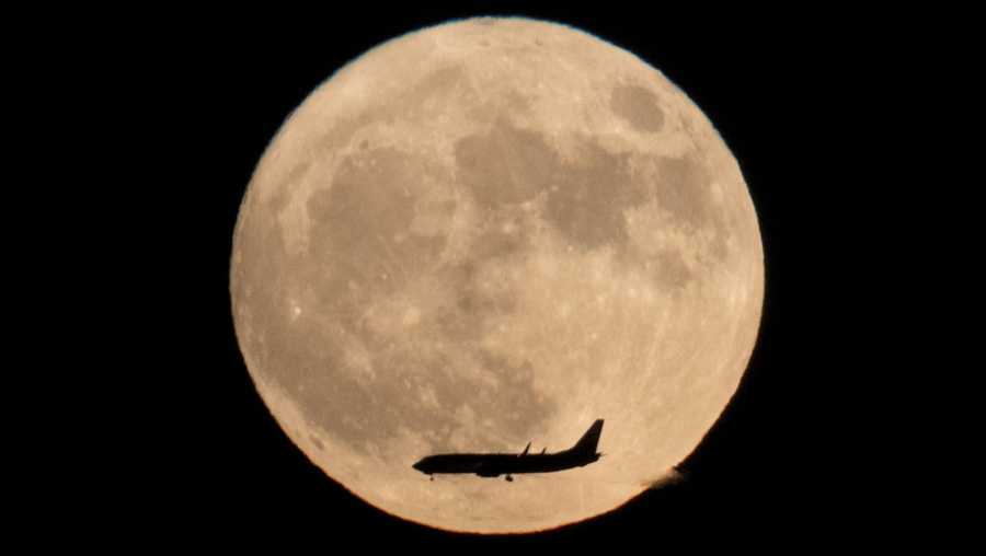 A jet plane flies across the moon seen from Beijing, China, Monday, Nov. 14, 2016. The brightest moon in almost 69 years lights up the sky on Monday in a treat for star watchers around the globe. The phenomenon is known as the supermoon.