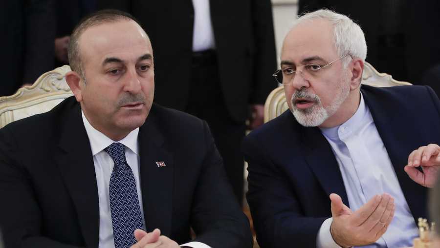 Turkey's Foreign Minister Mevlut Cavusoglu, left, and Iranian Foreign Minister Mohammad Javad Zarif talk to each other during their talks with Russian Foreign Minister Sergey Lavrov in Moscow, Russia, Tuesday, Dec. 20, 2016.