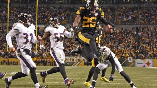 Le'Veon Bell leaps into the end zone ahead of Baltimore Ravens strong safety Eric Weddle for a touchdown 
