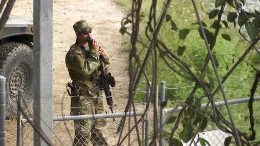 In this April 10, 2018 frame from video, a National Guard troop watches over Rio Grande River on the border in Roma, Texas.