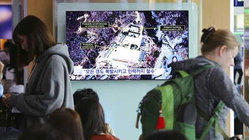 A TV screen shows a satellite image of the Punggye-ri nuclear test site in North Korea during a news program at the Seoul Railway Station in Seoul, South Korea, Sunday, May 13, 2018. The signs read: "Explode all tunnels."