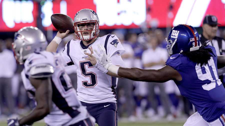 New England Patriots quarterback Danny Etling (5) throws a touchdown pass to running back Ralph Webb, left, as New York Giants linebacker Avery Moss (91) attacks during the second half of an NFL preseason football game, Thursday, Aug. 30, 2018, in East Rutherford. (AP Photo/Mark Lennihan)