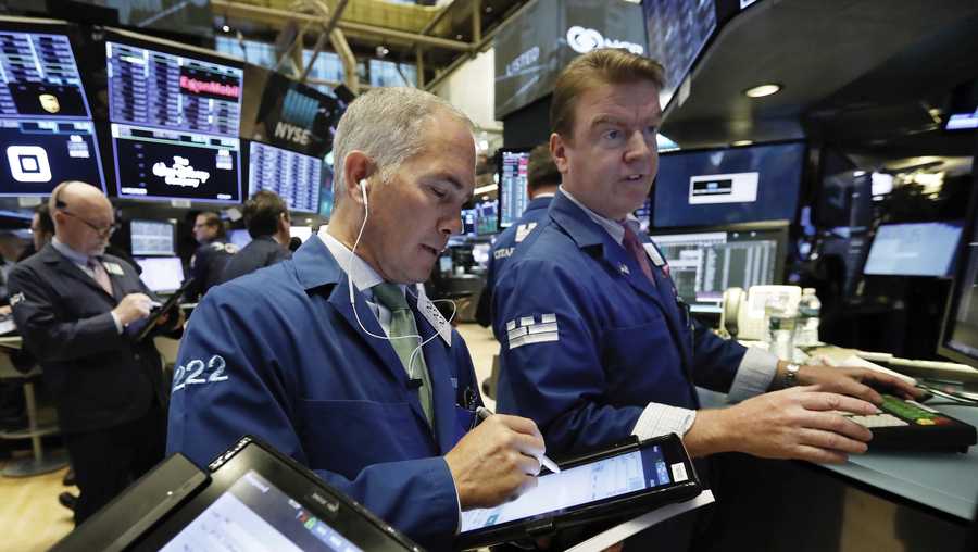 FILE- In this Nov. 7, 2018, file photo trader Timothy Nick, center, works with specialist Michael O'Mara on the floor of the New York Stock Exchange. The U.S. stock market opens at 9:30 a.m. EDT on Monday, Nov. 12. (AP Photo/Richard Drew, File)
