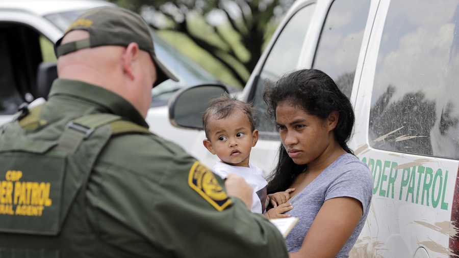 In this June 25, 2018, file photo, a mother migrating from Honduras holds her 1-year-old child as surrendering to U.S. Border Patrol agents after illegally crossing the border near McAllen, Texas. 