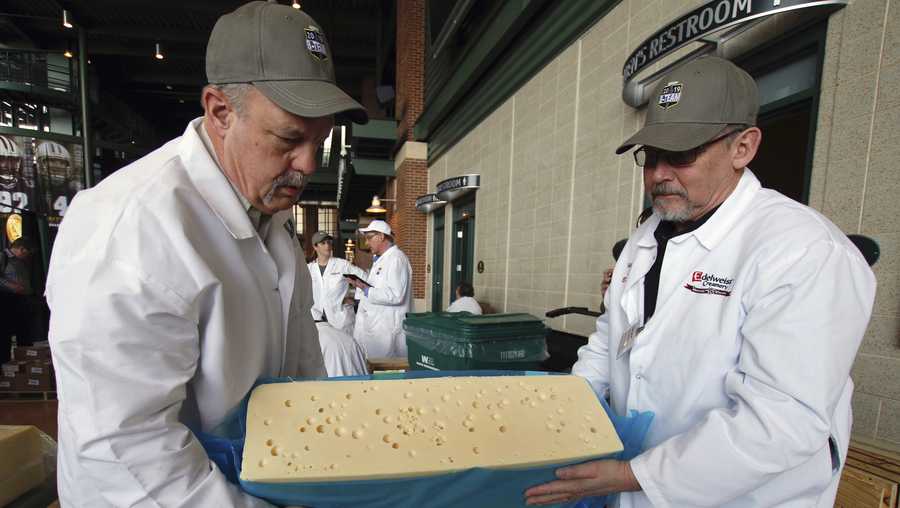 Steve Stettler, left, and Bruce Workman cut a piece a swiss cheesevat the United States Championship Cheese Contest  Tuesday, March 5, 2019 in Green Bay, Wis. The three-day event includes more cheese, butter and yogurt makers than ever before. It's is considered the largest technical cheese, butter and yogurt competition in the country. (AP Photo/Carrie Antlfinger)