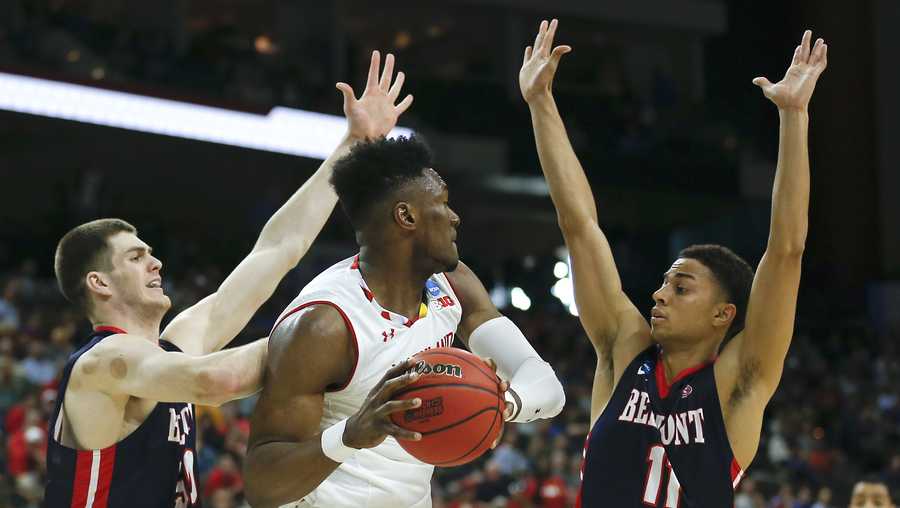 Maryland 's Bruno Fernando, center, looks to pass as he is caught between Belmont 's Seth Adelsperger, left, and Kevin McClain (11) during the first half of a first round men's college basketball game in the NCAA Tournament in Jacksonville, Fla., Thursday, March 21, 2019. (AP Photo/Stephen B. Morton)