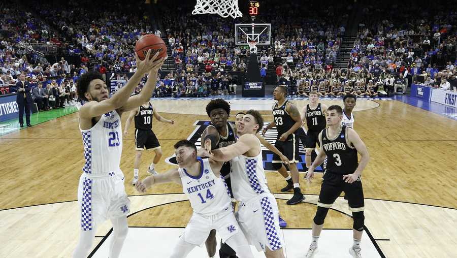 Kentucky's EJ Montgomery, left, grabs a Wofford rebound as Tyler Herro (14) holds back Wofford players during the first half of a second-round game in the NCAA men’s college basketball tournament in Jacksonville, Fla., Saturday, March 23, 2019. (AP Photo/Stephen B. Morton)