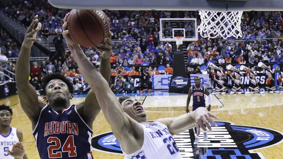 Auburn's Anfernee McLemore (24) and Kentucky's Reid Travis (22) reach for a rebound during the first half of the Midwest Regional final game in the NCAA men's college basketball tournament Sunday, March 31, 2019, in Kansas City, Mo. (AP Photo/Charlie Riedel)