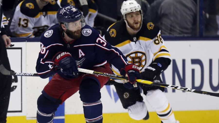 Columbus Blue Jackets forward Boone Jenner, left, chases the puck next to Boston Bruins forward David Pastrnak, of the Czech Republic, during the second period of Game 4 of an NHL hockey second-round playoff series in Columbus, Ohio, Thursday, May 2, 2019. (AP Photo/Paul Vernon)