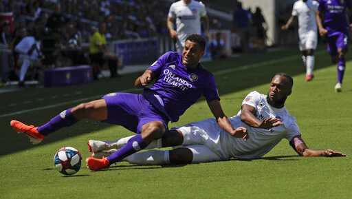 Orlando City's Tesho Akindele, left, and FC Cincinnati's Kendall Waston battle for possession of the ball during the first half of an MLS soccer match, Sunday, May 19, 2019, in Orlando, Fla. (AP Photo/John Raoux)