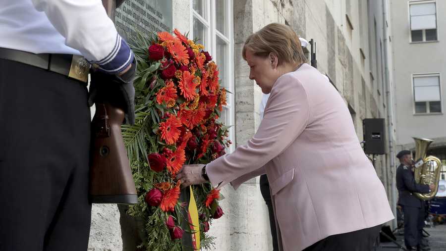 German Chancellor Angela Merkel adjusts a wreath during a memorial event at the Defence Ministry in Berlin, Germany, Saturday, July 20, 2019. On July 20, 2019 Germany marks the 75th anniversary of the failed attempt to kill Hitler in 1944.
