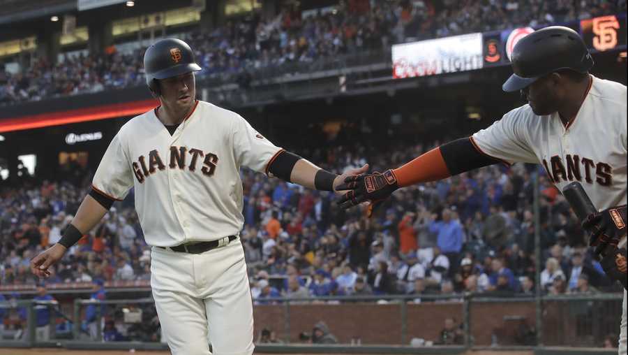 San Francisco Giants' Joe Panik, left, is congratulated by Pablo Sandoval after scoring a run against the Chicago Cubs during the fifth inning of a baseball game in San Francisco, Monday, July 22, 2019. (AP Photo/Jeff Chiu)