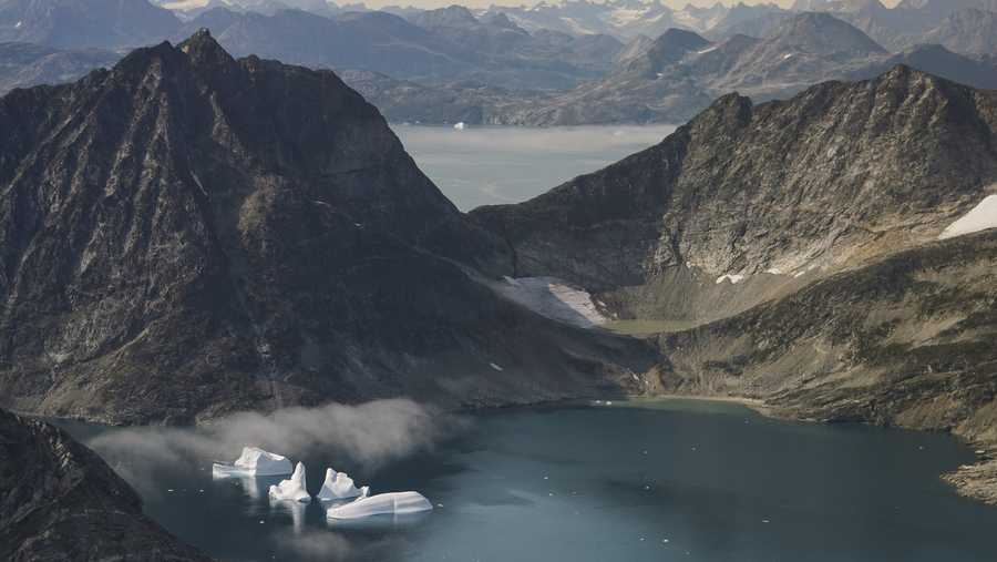 In this photo taken on Wednesday, Aug. 14, 2019, icebergs are photographed from the window of an airplane carrying NASA Scientists as they fly on a mission to track melting ice in eastern Greenland. Greenland has been melting faster in the last decade and this summer, it has seen two of the biggest melts on record since 2012. (AP Photo/Mstyslav Chernov)
