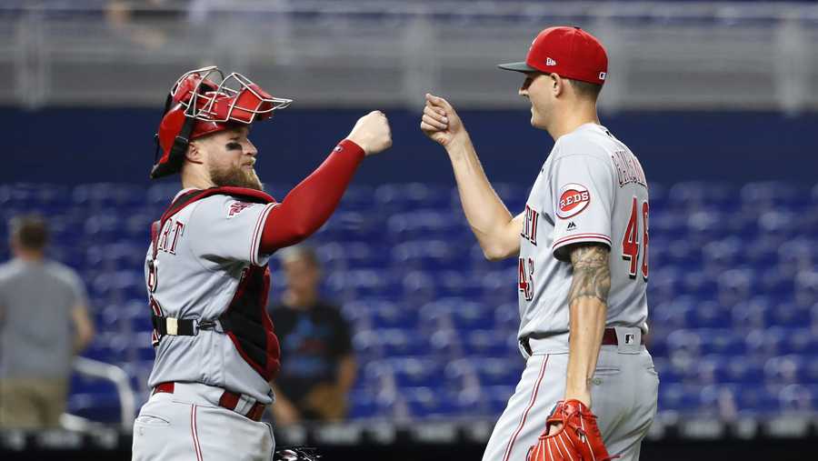 Cincinnati Reds relief pitcher Kevin Gausman (46) and catcher Tucker Barnhart celebrate after the Reds defeated the Miami Marlins 5-0 during a baseball game, Wednesday, Aug. 28, 2019, in Miami. (AP Photo/Wilfredo Lee)