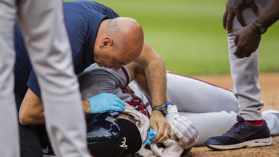 Atlanta Braves Charlie Culberson drops on the ground after getting hit by a ball during the seventh inning of a baseball game against the Washington Nationals in Washington, Saturday, Sept. 14, 2019.