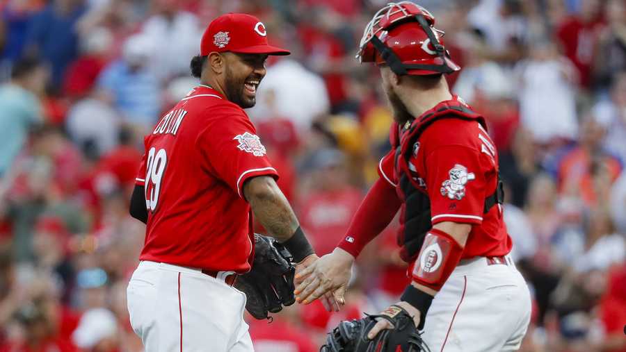 Cincinnati Reds second baseman Christian Colon (29) celebrates with catcher Tucker Barnhart, right, after closing the ninth inning of a baseball game against the New York Mets, Saturday, Sept. 21, 2019, in Cincinnati. (AP Photo/John Minchillo)