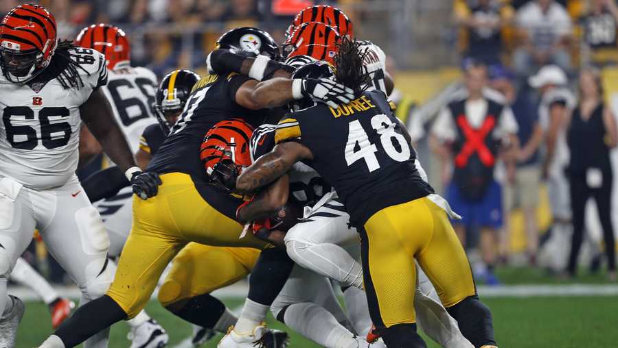 Cincinnati Bengals running back Joe Mixon, center, is tackled by Pittsburgh Steelers defensive end Cameron Heyward, left, and outside linebacker Bud Dupree (48) during the first half of an NFL football game in Pittsburgh, Monday, Sept. 30, 2019. (AP Photo/Tom Puskar)