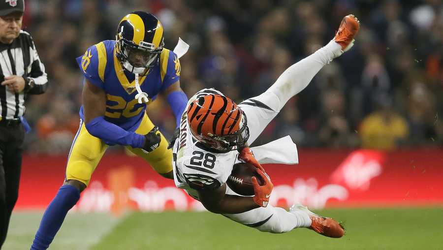 Cincinnati Bengals running back Joe Mixon (28) is tackled by Los Angeles Rams cornerback Troy Hill (20) during the second half of an NFL football game, Sunday, Oct. 27, 2019, at Wembley Stadium in London. (AP Photo/Tim Ireland)