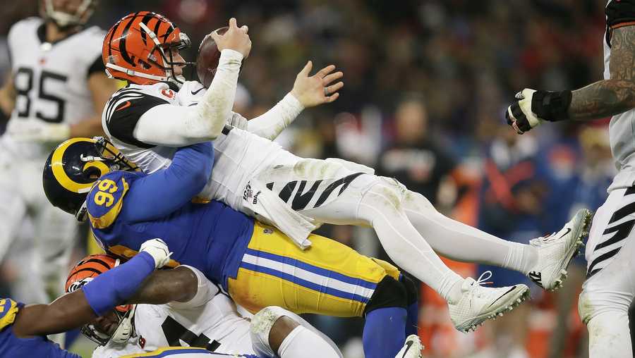 Cincinnati Bengals quarterback Andy Dalton, top, is sacked by Los Angeles Rams defensive tackle Aaron Donald during the second half of an NFL football game, Sunday, Oct. 27, 2019, at Wembley Stadium in London. (AP Photo/Tim Ireland)